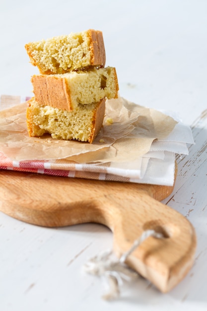 Graanbrood dat in peaces op witte houten achtergrond wordt gesneden