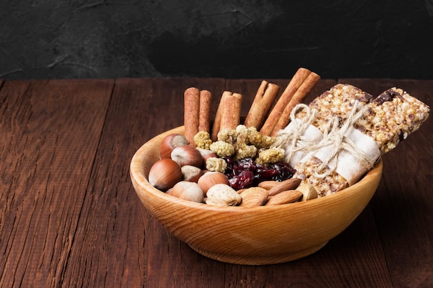 Graanrepen met noten, bessen en kaneel op een houten achtergrond