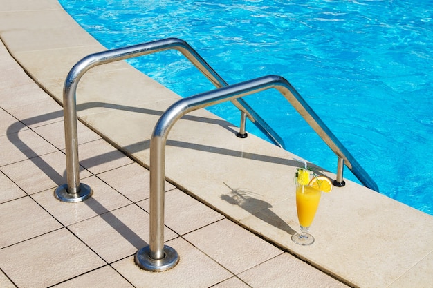 Grab bars ladder in the blue swimming pool