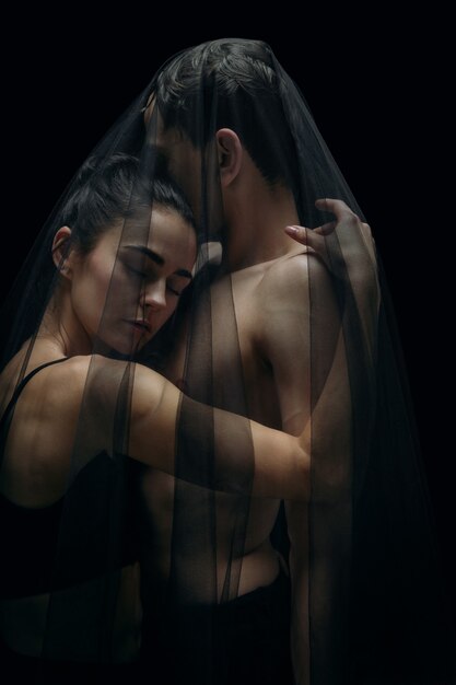 Graceful classic ballet dancers isolated on black studio background.