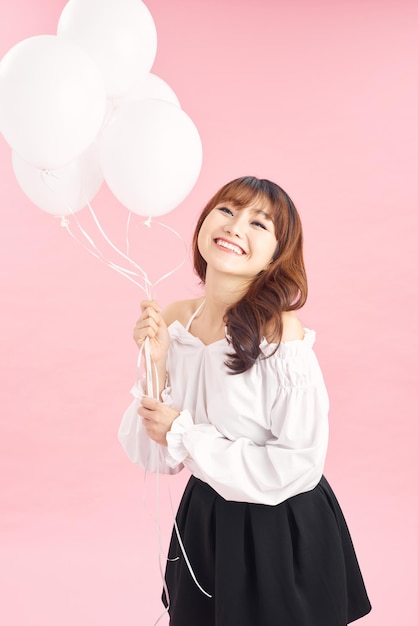 Graceful slim birthday girl posing with balloons