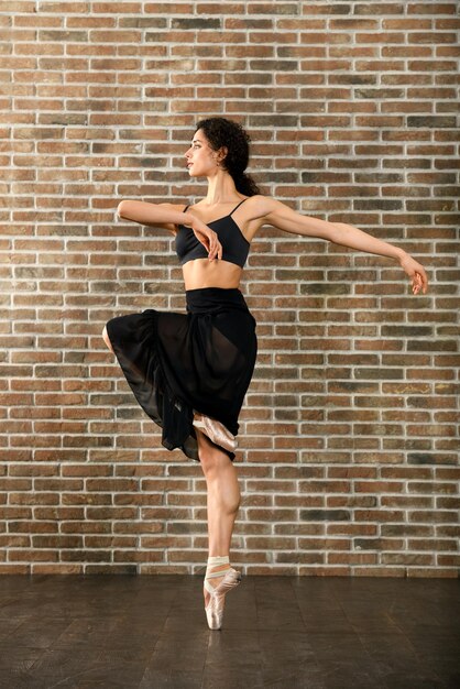 Graceful young ballerina rehearsing in a studio