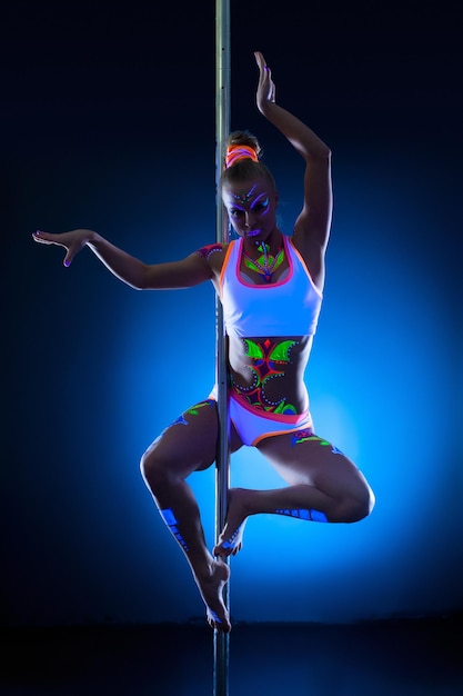 Photo graceful young pole dancer with fluorescent makeup