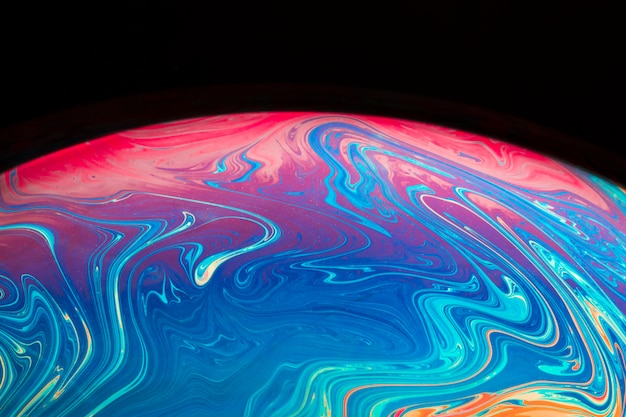 Gradient iridescent translucent soap bubble on black background