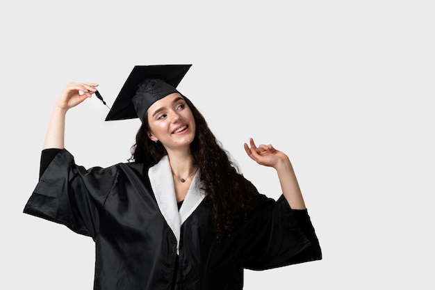 Graduate girl with master degree in black graduation gown and cap.