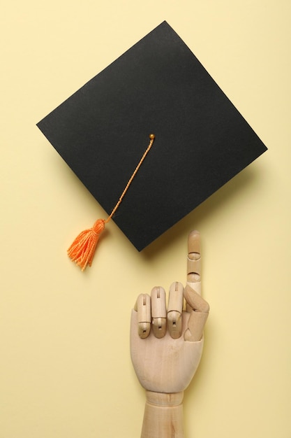 Graduate hat and diploma on yellow background