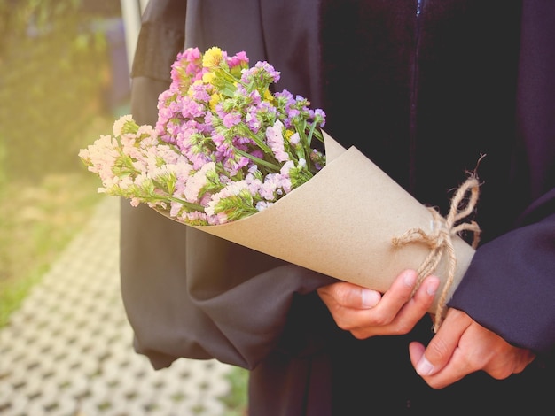 졸업식 날 꽃다발을 들고 있는 졸업생
