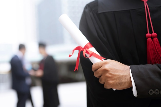 Photo graduate holding a diploma in hand