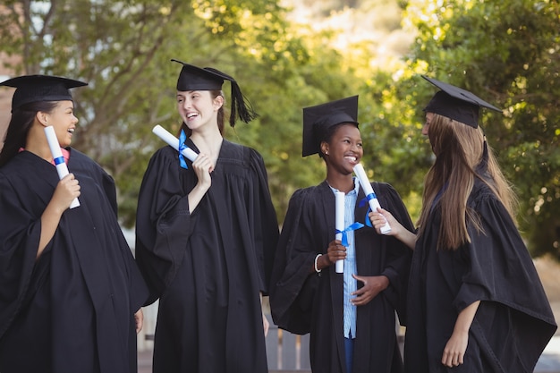 Graduate school kids staan met graad scroll in campus op school
