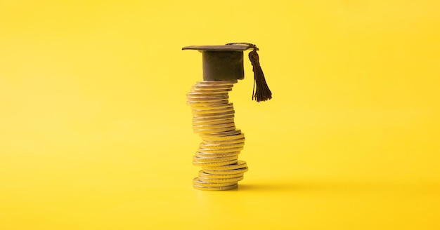 Photo graduated cap with coins on yellow background savings for education concept