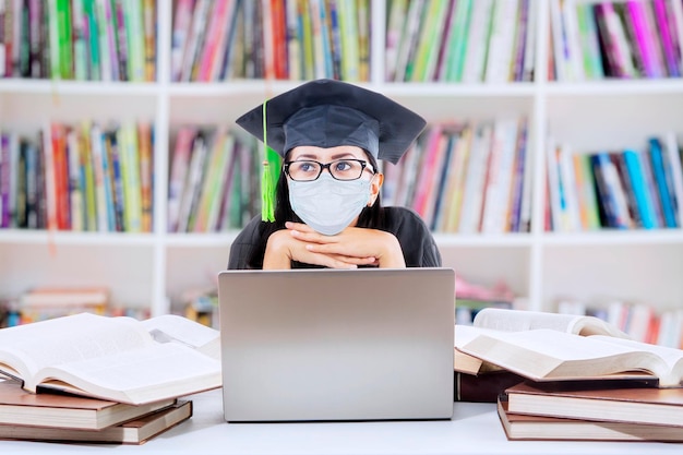 Graduating female student wear mask in library