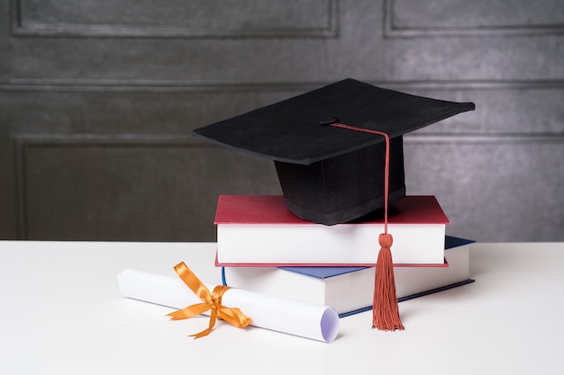 Graduation cap with books on white desk , Education background