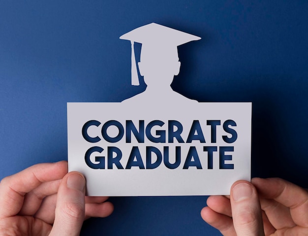 Graduation card Male hands holding card with graduate cutout