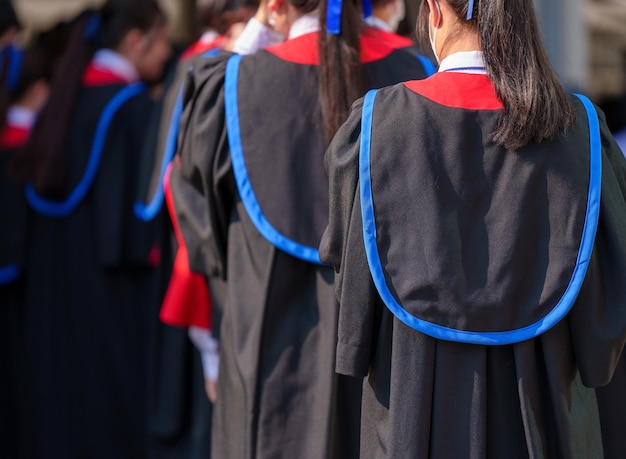 Foto cerimonia di laurea degli studenti che indossano sparviere alla cerimonia di laurea da dietro