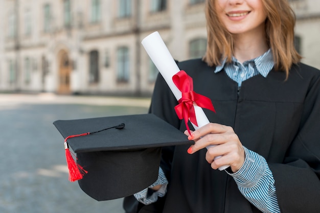 Concetto di laurea con ragazza che tiene il suo diploma