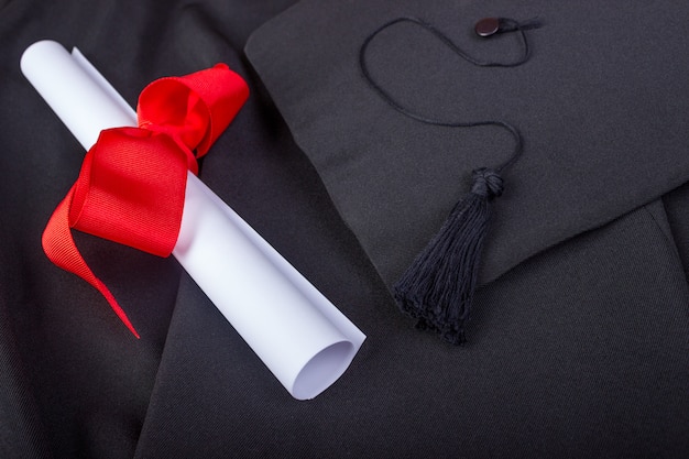 Foto giorno della laurea. un abito, cappello di laurea e diploma e pronto per il giorno della laurea