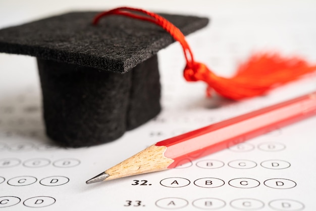 Foto cappello di laurea e matita sullo sfondo del foglio di risposta studio di istruzione apprendimento della matematica concetto di insegnamento