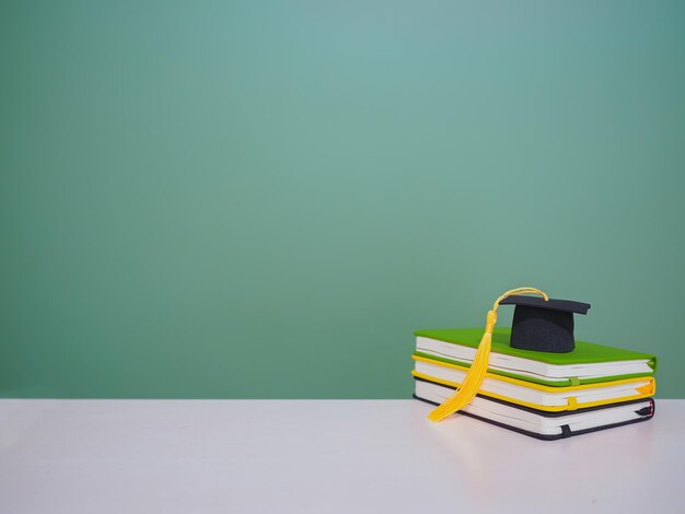 Graduation hat on stack hardcover book Copy space for text Back to school Education concept