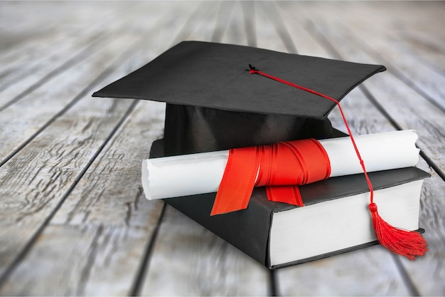 Graduation mortarboard on  book on  background