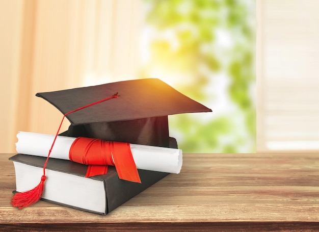 Graduation mortarboard on  book on  background