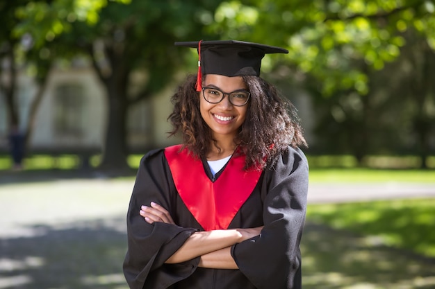 Graduation. pretty young girl in academic cap feeling happy\
about graduation