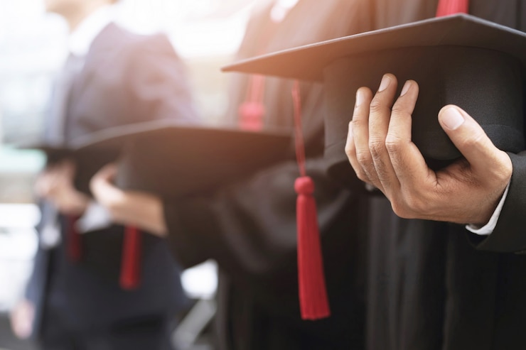 Photo graduation, student hold hats in hand during commencement success graduates of the university