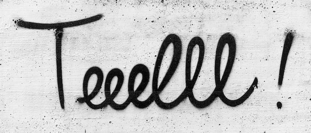 Graffiti in a concrete wall with the text TELL