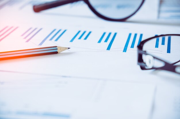 grafieken en diagrammen met vergrootglas en potlood, rekenmachine, klok. Reflectielicht en flare. Conceptbeeld van gegevensverzameling en statistisch werken.