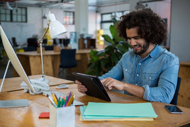 Grafisch ontwerper met behulp van digitale tablet in creatief kantoor