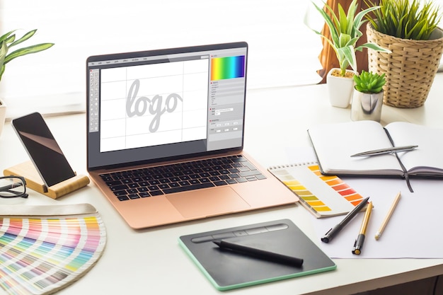 Grafische ontwerpstudio met logo-ontwerp op laptopscherm