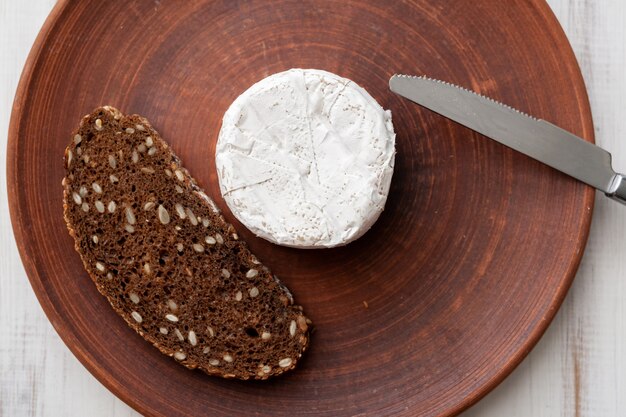 Grain bread and blue cheese on a brown clay plate