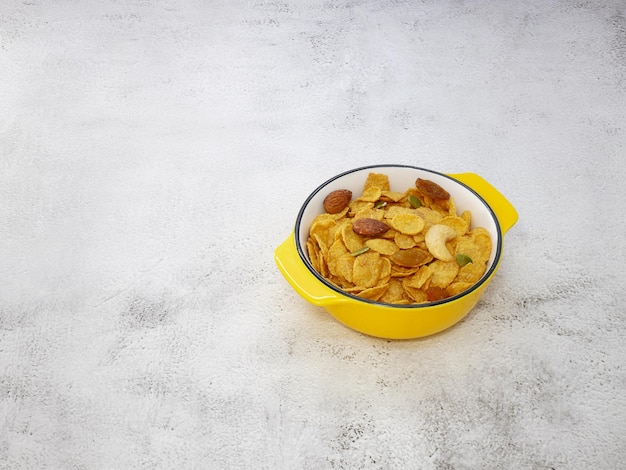 Photo grains cornflakes in bowl on white texture background