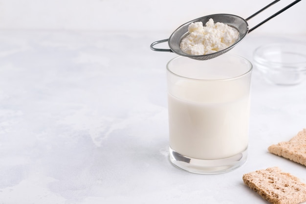 Grains of milk kefir. Fermented drink in a glass.