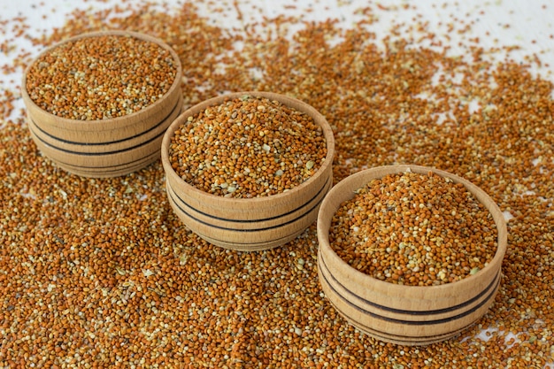 Grains of millet in a wooden a box. Grains of millet on a white background
