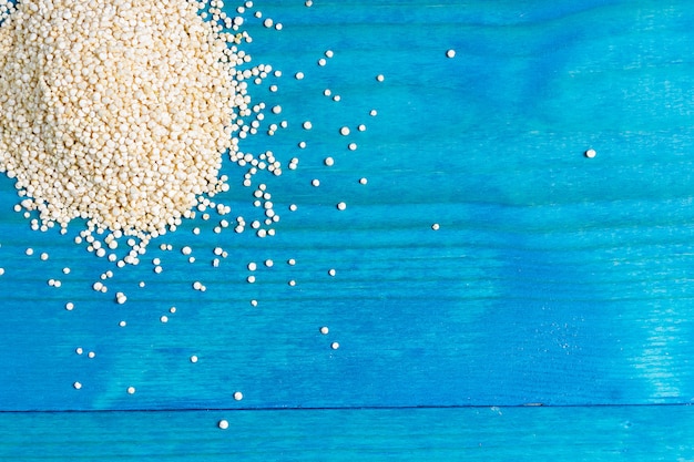 Foto grani di quinoa su un backgound in legno blu con spazio per il testo