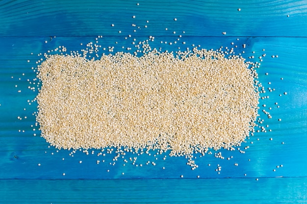 Grains of quinoa on a blue wooden backgound with space for text