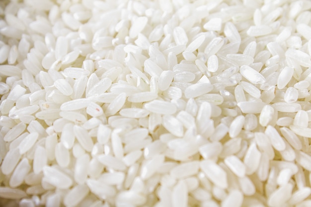 Grains of raw white rice on a white wooden table of boards. Ingredients for cooking.