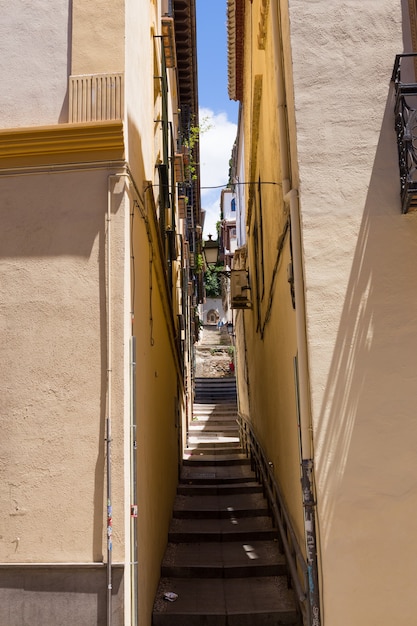 Granada, Andalusia, Spain - May 26, 2019: narrow street with stairs between old houses, architecture of Granada.