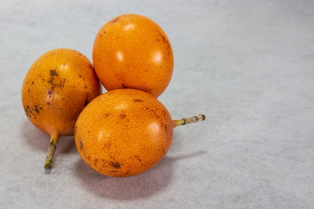 Granadilla a hardskinned orangecolored Peruvian fruit with seeds wrapped in a pleasant jellylik