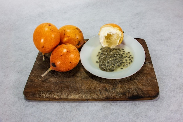 Foto granadilla un frutto peruviano dalla pelle dura su un piatto di porcellana e una tavola di legno