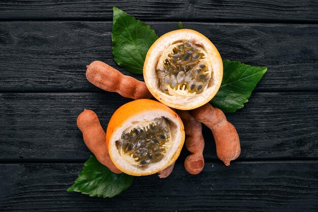 Granadilla and Tamarind Fresh Tropical Fruits On a wooden background Top view Copy space