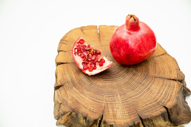 granaten op een snijplank. gesneden granaatappelfruit op dwarsdoorsnede van eikenbosje. bovenaanzicht. Kopieer ruimte