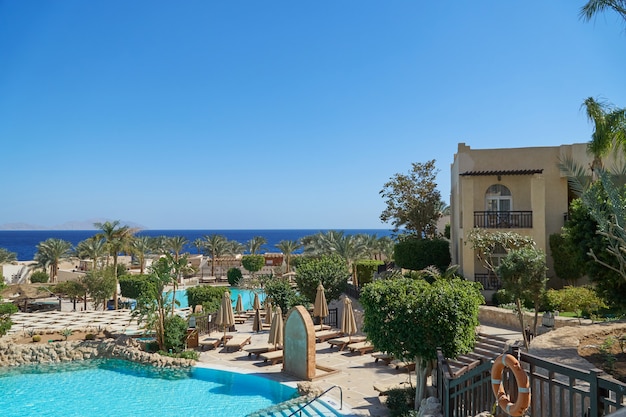 Grand Hotel with palms and swimming pool in summer