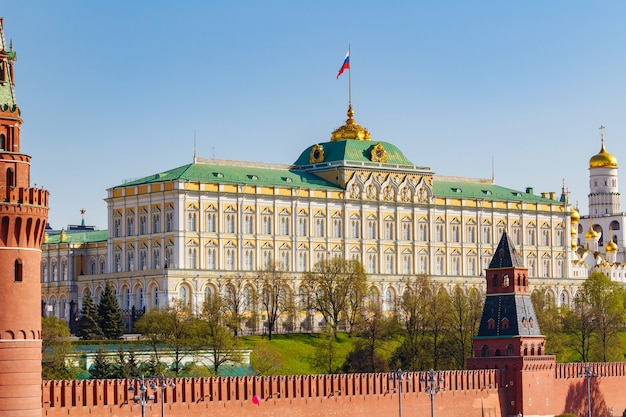 Grand Kremlin Palace van het Kremlin van Moskou met Russische vlag zwaaien tegen blauwe hemel