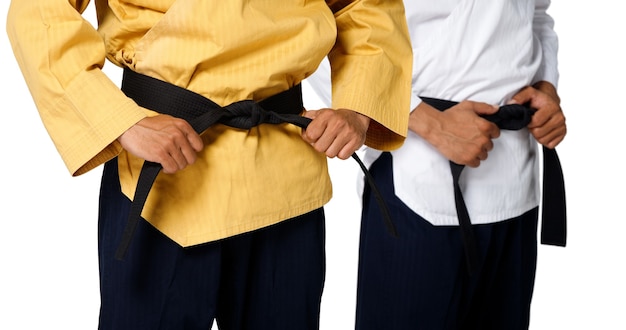 Foto grand master black belt taekwondo insegnante tenere e legare la posa della cintura, parte in vita studio su sfondo bianco isolato