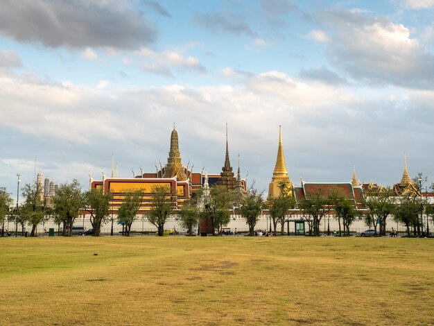 Grand Royal Palace view from central park in Bangkok Thailand under cloudy sky