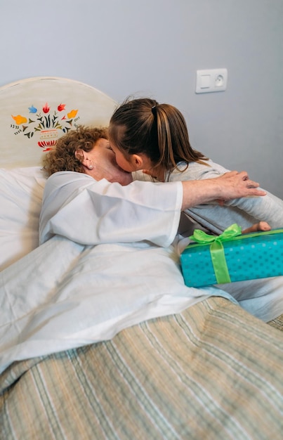 Granddaughter bringing a gift to her sick grandmother in the hospital