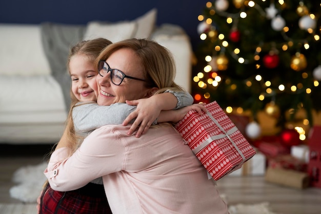 Granddaughter embracing little girl in Christmas time