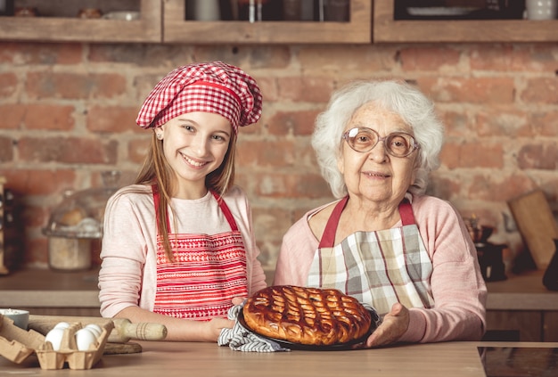 Granddaughter and her granny with fruit pie