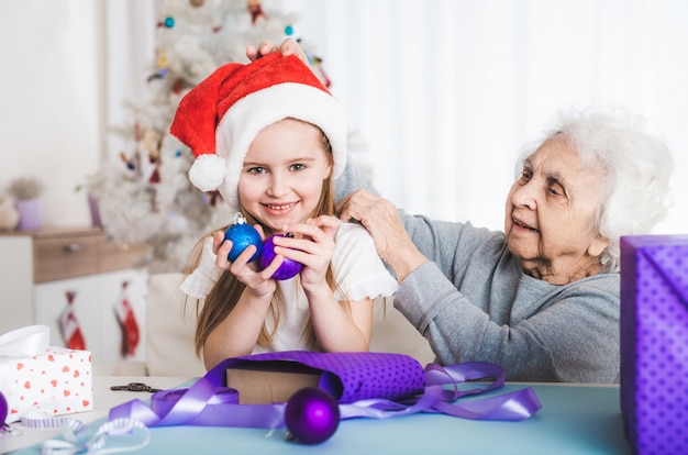 Granddaughter sit with grandma holding balls